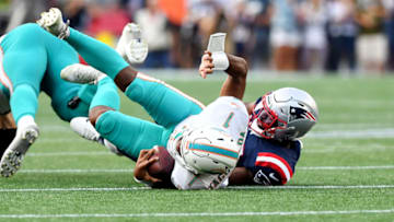 Sep 12, 2021; Foxborough, Massachusetts, USA; Miami Dolphins quarterback Tua Tagovailoa (1) is sacked by New England Patriots linebacker Josh Uche (55) during the first half at Gillette Stadium. Mandatory Credit: Brian Fluharty-USA TODAY Sports