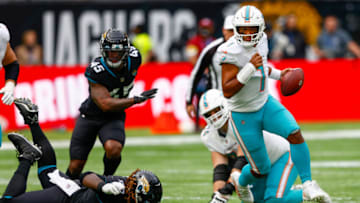 Oct 17, 2021; London, England, United Kingdom; Miami Dolphins quarterback Tua Tagovailoa (1) runs with the ball in the first half against the Jacksonville Jaguars at Tottenham Hotspur Stadium. Mandatory Credit: Nathan Ray Seebeck-USA TODAY Sports