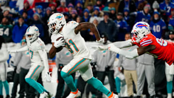 Dec 17, 2022; Orchard Park, New York, USA; Miami Dolphins running back Raheem Mostert (31) runs with the ball against Buffalo Bills defensive end Shaq Lawson (90) during the first half at Highmark Stadium. Mandatory Credit: Gregory Fisher-USA TODAY Sports