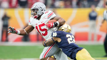 Jan 1, 2016; Glendale, AZ, USA; Ohio State Buckeyes running back Ezekiel Elliott (15) is tackled by Notre Dame Fighting Irish safety Elijah Shumate (22) in the first quarter in the 2016 Fiesta Bowl at University of Phoenix Stadium. Mandatory Credit: Matt Cashore-USA TODAY Sports