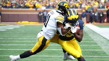 ANN ARBOR, MICHIGAN - OCTOBER 05: Mike Sainristil #19 of the Michigan Wolverines battles for yards after a first quarter catch against Michael Ojemudia #11 of the Iowa Hawkeyes at Michigan Stadium on October 05, 2019 in Ann Arbor, Michigan. (Photo by Gregory Shamus/Getty Images)