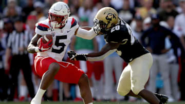 BOULDER, COLORADO - OCTOBER 05: Brian Casteel #5 of the Arizona Wildcats tries to break free from Davion Taylor #20 of the Colorado Buffaloes in the second quarter at Folsom Field on October 05, 2019 in Boulder, Colorado. (Photo by Matthew Stockman/Getty Images)