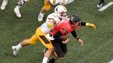 LAS VEGAS, NV - NOVEMBER 12: Linebacker Logan Wilson #30 of the Wyoming Cowboys tackles quarterback Kurt Palandech #14 of the UNLV Rebels after he rushed for five yards during their game at Sam Boyd Stadium on November 12, 2016 in Las Vegas, Nevada. UNLV won 69-66 in triple overtime. (Photo by Ethan Miller/Getty Images)