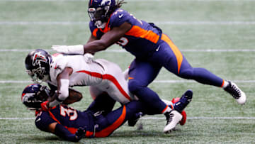 ATLANTA, GEORGIA - NOVEMBER 08: Justin Simmons #31 and McTelvin Agim #95 of the Denver Broncos tackle Julio Jones #11 of the Atlanta Falcons during the first half at Mercedes-Benz Stadium on November 08, 2020 in Atlanta, Georgia. (Photo by Kevin C. Cox/Getty Images)
