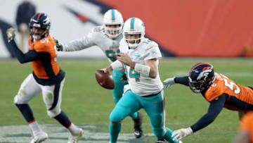 DENVER, COLORADO - NOVEMBER 22: Ryan Fitzpatrick #14 of the Miami Dolphins falls as he is tackled by Bradley Chubb #55 of the Denver Broncos during the fourth quarter at Empower Field At Mile High on November 22, 2020 in Denver, Colorado. (Photo by Matthew Stockman/Getty Images)