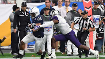 GLENDALE, AZ - DECEMBER 30: Saquon Barkley #26 of Penn State Nittany Lions runs through an arm tackle by Keishawn Bierria #7 of the Washington Huskies during the first quarter of the Playstation Fiesta Bowl at University of Phoenix Stadium on December 30, 2017 in Glendale, Arizona. (Photo by Norm Hall/Getty Images)