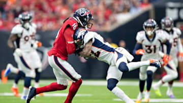 HOUSTON, TX - DECEMBER 8: DeAndre Hopkins #10 of the Houston Texans is hit and drops a pass by Kareem Jackson #22 of the Denver Broncos during the first half at NRG Stadium on December 8, 2019 in Houston, Texas. (Photo by Wesley Hitt/Getty Images)