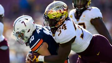 Jan 1, 2020; Tampa, Florida, USA; Auburn Tigers quarterback Bo Nix (10) scrambles with the ball as Minnesota Golden Gophers defensive lineman Boye Mafe (34) defends during the second quarter at Raymond James Stadium. Mandatory Credit: Douglas DeFelice-USA TODAY Sports