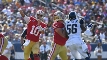 LOS ANGELES, CA - OCTOBER 13: Jimmy Garoppolo #10 of the San Francisco 49ers throws a pass while Justin Skule #67 blocks Dante Fowler #56 of the Los Angeles Rams in the third quarter at Los Angeles Memorial Coliseum on October 13, 2019 in Los Angeles, California. (Photo by John McCoy/Getty Images)