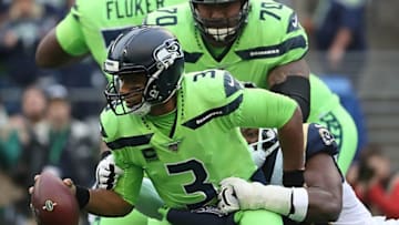SEATTLE, WASHINGTON - OCTOBER 03: Quarterback Russell Wilson #3 of the Seattle Seahawks is wrapped up by the defense of the Los Angeles Rams in the game at CenturyLink Field on October 03, 2019 in Seattle, Washington. (Photo by Abbie Parr/Getty Images)