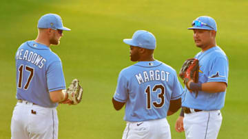 PORT CHARLOTTE, FLORIDA - MARCH 11: Manuel Margot #13 and Yoshitomo Tsutsugo #25 of the Tampa Bay Rays meet with Austin Meadows #17 in the outfield during a pitcher change in the second inning of a Grapefruit League spring training game against the Boston Red Sox at Charlotte Sports Park on March 11, 2020 in Port Charlotte, Florida. (Photo by Julio Aguilar/Getty Images)