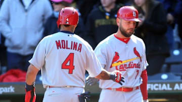 Apr 3, 2016; Pittsburgh, PA, USA; St. Louis Cardinals catcher Yadier Molina (4) is greeted by first baseman Matt Holliday (7) after Molina scored a run against the Pittsburgh Pirates during the ninth inning at PNC Park. The Pirates won 4-1. Mandatory Credit: Charles LeClaire-USA TODAY Sports