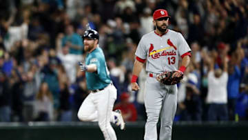 Jun 24, 2016; Seattle, WA, USA; St. Louis Cardinals third baseman Matt Carpenter (13) walks back to the dugout as Seattle Mariners designated hitter Adam Lind (26) runs the bases after hitting a walk-off three-run homer during the ninth inning at Safeco Field. Seattle defeated St. Louis, 4-3. Mandatory Credit: Joe Nicholson-USA TODAY Sports