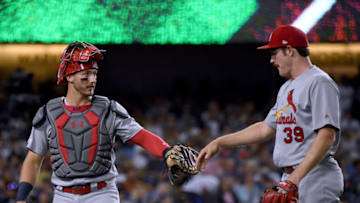LOS ANGELES, CALIFORNIA - AUGUST 06: Andrew Knizner #7 and Miles Mikolas #39 of the St. Louis Cardinals celebrate the end of the third inning against the Los Angeles Dodgers at Dodger Stadium on August 06, 2019 in Los Angeles, California. (Photo by Harry How/Getty Images)