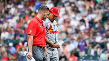 Carlos Martinez #18 of the St. Louis Cardinals is tended to by a trainer after an apparent injury while pitching against the Colorado Rockies at Coors Field on July 4, 2021 in Denver, Colorado. (Photo by Dustin Bradford/Getty Images)