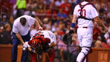 ST. LOUIS, MO - SEPTEMBER 25: A member of the St. Louis Cardinals training staff helps Yadier Molina #4 of the St. Louis Cardinals off the field after Molina was hit in the helmet by consecutive pitches in the seventh inning against the Chicago Cubs at Busch Stadium on September 25, 2017 in St. Louis, Missouri. (Photo by Dilip Vishwanat/Getty Images)