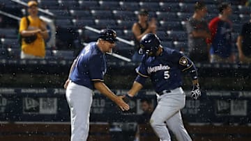 Milwaukee Brewers third base coach Ed Sedar (6) congratulates shortstop Jonathan Villar (5) on a home run against the Atlanta Braves earlier this season. Mandatory Credit: Brett Davis-USA TODAY Sports