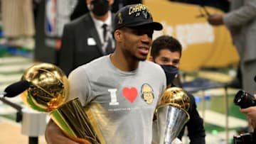 MILWAUKEE, WISCONSIN - JULY 20: Giannis Antetokounmpo #34 of the Milwaukee Bucks holds the Bill Russell NBA Finals MVP Award and the Larry O'Brien Championship Trophy after defeating the Phoenix Suns in Game Six to win the 2021 NBA Finals at Fiserv Forum on July 20, 2021 in Milwaukee, Wisconsin. NOTE TO USER: User expressly acknowledges and agrees that, by downloading and or using this photograph, User is consenting to the terms and conditions of the Getty Images License Agreement. (Photo by Justin Casterline/Getty Images)