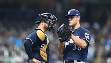 MILWAUKEE, WI - JUNE 26: Dan Jennings #38 of the Milwaukee Brewers speaks with Manny Pina #9 during the eighth inning of a game against the Kansas City Royals at Miller Park on June 26, 2018 in Milwaukee, Wisconsin. (Photo by Stacy Revere/Getty Images)