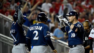 WASHINGTON, DC - OCTOBER 01: Yasmani Grandal #10 of the Milwaukee Brewers celebrates with Mike Moustakas #11 and Trent Grisham #2 after hitting a two run home run against Max Scherzer #31 of the Washington Nationals during the first inning in the National League Wild Card game at Nationals Park on October 01, 2019 in Washington, DC. (Photo by Will Newton/Getty Images)