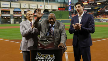 Oct 23, 2019; Houston, TX, USA; Hall of Fame member Hank Aaron (at podium) is joined by Major League Baseball chief baseball officer Joe Torre (left) and Milwaukee Brewers outfielder Christian Yelich (right) for a presentation of the 2019 Hank Aaron Awards before the first inning of game two of the 2019 World Series between the Houston Astros and the Washington Nationals at Minute Maid Park. Mandatory Credit: Matt Slocum/Pool Photo via USA TODAY Sports
