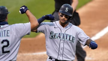 Sep 26, 2020; Oakland, California, USA; Seattle Mariners right fielder Tim Lopes (10) celebrates with first baseman Evan White (12) after hitting a home run against the Oakland Athletics during the sixth inning at Oakland Coliseum. Mandatory Credit: Darren Yamashita-USA TODAY Sports