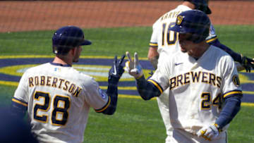 Mar 6, 2021; Phoenix, Arizona, USA; Milwaukee Brewers center fielder Avisail Garcia (24) celebrates with second baseman Daniel Robertson (28) after scoring a run again st the Chicago Cubs during a spring training game at American Family Fields of Phoenix. Mandatory Credit: Rick Scuteri-USA TODAY Sports