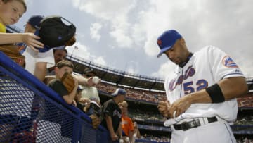 FLUSHING, NY - JULY 12: Tony Clark #52 of the New York Mets autographs a baseball for a fan before the game against the Philadelphia Phillies on July 12, 2003 at Shea Stadium in Flushing, New York. The Phillies defeated the Mets in 11 innings 4-2. (Photo by Chris Trotman/Getty Images)