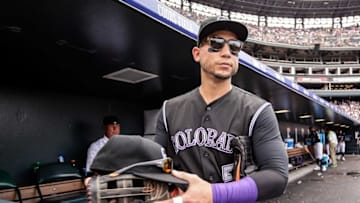 Jul 24, 2016; Denver, CO, USA; Colorado Rockies right fielder Carlos Gonzalez (5) gabs the hat and glove of center fielder Charlie Blackmon (not pictured) in the third inning against the Atlanta Braves at Coors Field. Mandatory Credit: Isaiah J. Downing-USA TODAY Sports