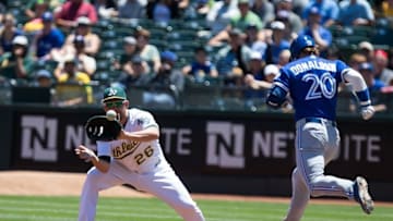 Jul 17, 2016; Oakland, CA, USA; Toronto Blue Jays third baseman Josh Donaldson (20) safe at first base against Oakland Athletics first baseman Danny Valencia (26) during the first inning at O.co Coliseum. Mandatory Credit: Kelley L Cox-USA TODAY Sports