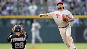 Jul 7, 2016; Denver, CO, USA; Philadelphia Phillies shortstop Freddy Galvis (13) attempts to turn a double play over the slide of Colorado Rockies third baseman Nolan Arenado (28) in the third inning at Coors Field. Mandatory Credit: Ron Chenoy-USA TODAY Sports