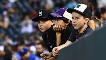 Aug 3, 2016; Denver, CO, USA; Colorado Rockies fans hang over a wall during a break in the in the fifth inning of the game against the Los Angeles Dodgers at Coors Field. Mandatory Credit: Ron Chenoy-USA TODAY Sports