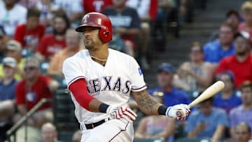 Aug 10, 2016; Arlington, TX, USA; Texas Rangers center fielder Ian Desmond (20) hits a run scoring single in the second inning against the Colorado Rockies at Globe Life Park in Arlington. Mandatory Credit: Ray Carlin-USA TODAY Sports