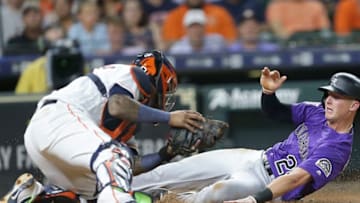 HOUSTON, TX - AUGUST 14: Ryan McMahon #24 of the Colorado Rockies scores in the seventh inning as Martin Maldonado #15 of the Houston Astros is unable to make the tag at Minute Maid Park on August 14, 2018 in Houston, Texas. (Photo by Bob Levey/Getty Images)