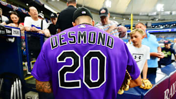 ST PETERSBURG, FLORIDA - APRIL 02: Ian Desmond #20 of the Colorado Rockies signs autographs for fans before a game against the Tampa Bay Rays at Tropicana Field on April 02, 2019 in St Petersburg, Florida. (Photo by Julio Aguilar/Getty Images)