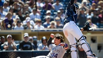 SAN DIEGO, CA - AUGUST 11: Tony Wolters #14 of the Colorado Rockies scores as Francisco Mejia #27 of the San Diego Padres loses the ball during the eighth inning of a baseball game at Petco Park August 11, 2019 in San Diego, California. (Photo by Denis Poroy/Getty Images)