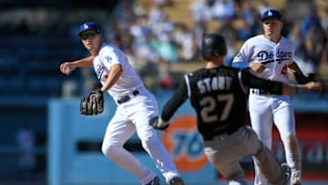 LOS ANGELES, CA - SEPTEMBER 22: Corey Seager #5 of the Los Angeles Dodgers throws to first from second as he catches Trevor Story #27 of the Colorado Rockies in a double play and Gavin Lux #48 looks on in th eighth inning at Dodger Stadium on September 22, 2019 in Los Angeles, California. The Dodgers won 7-4. (Photo by John McCoy/Getty Images)