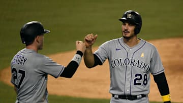 LOS ANGELES, CA - SEPTEMBER 05: Nolan Arenado #28 and Trevor Story #27 of the Colorado Rockies celebrate after scoring on a double by Josh Fuentes #8 against relief pitcher Alex Wood #57 of the Los Angeles Dodgers during the ninth inning at Dodger Stadium on September 5, 2020 in Los Angeles, California. (Photo by Kevork Djansezian/Getty Images)