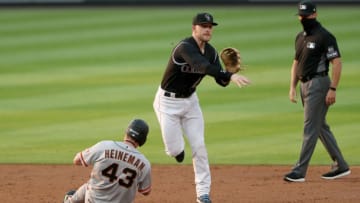 DENVER, COLORADO - AUGUST 05: Trevor Story #27 of the Colorado Rockies turns the first half of a double against Tyler Heineman #43 of the San Francisco Giants in the third inning at Coors Field on August 05, 2020 in Denver, Colorado. (Photo by Matthew Stockman/Getty Images)