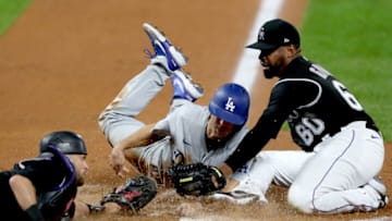DENVER, COLORADO - SEPTEMBER 19: Austin Barnes #15 of the Los Angeles Dodgers scores against catcher Drew Butera #6 and pitcher Mychal Givens #60 of the Colorado Rockies on a wild pitch in the seventh inning at Coors Field on September 19, 2020 in Denver, Colorado. (Photo by Matthew Stockman/Getty Images)