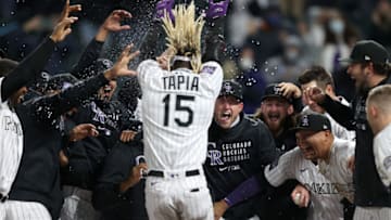 DENVER, COLORADO - APRIL 23: Raimel Tapia #15 of the Colorado Rockies is met at home plate by his teammates after hitting a walk off home run against the Philadelphia Phillies in the ninth inning at Coors Field on April 23, 2021 in Denver, Colorado. (Photo by Matthew Stockman/Getty Images)