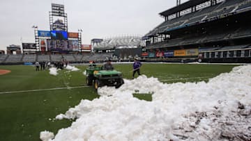 DENVER, CO - APRIL 16: Team employees work to remove snow from the field as the New York Mets and the Colorado Rockies prepare for a double header at Coors Field on April 16, 2013 in Denver, Colorado. All uniformed team members are wearing jersey number 42 in honor of Jackie Robinson Day. (Photo by Doug Pensinger/Getty Images)