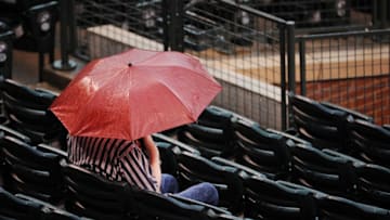DENVER, CO - JULY 18: A fan of the Colorado Rockies sits in the rain prior to the game against the Tampa Bay Rays at Coors Field on July 18, 2016 in Denver, Colorado. (Photo by Bart Young/Getty Images)