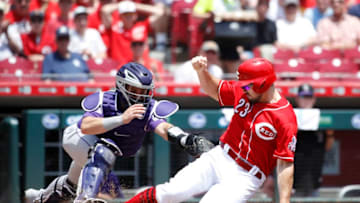 CINCINNATI, OH - JUNE 07: Adam Duvall #23 of the Cincinnati Reds slides home with a run ahead of the tag by Tony Wolters #14 of the Colorado Rockies in the second inning at Great American Ball Park on June 7, 2018 in Cincinnati, Ohio. (Photo by Joe Robbins/Getty Images)
