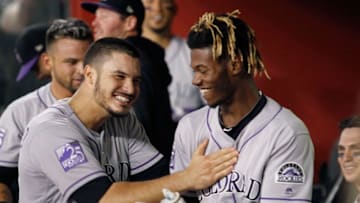 PHOENIX, AZ - JULY 20: Raimel Tapia #15 of the Colorado Rockies (R) is congratulated by teammate Nolan Arenado #28 after Tapia hit a grand slam home run against the Arizona Diamondbacks during the seventh inning of an MLB game at Chase Field on July 20, 2018 in Phoenix, Arizona. (Photo by Ralph Freso/Getty Images)