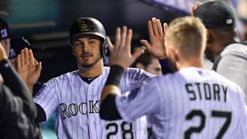 DENVER, CO - SEPTEMBER 24: Nolan Arenado #28 of the Colorado Rockies is congratulated in the dugout by Trevor Story #27 after scoring a run in the third inning of a game against the Philadelphia Phillies at Coors Field on September 24, 2018 in Denver, Colorado. (Photo by Dustin Bradford/Getty Images)