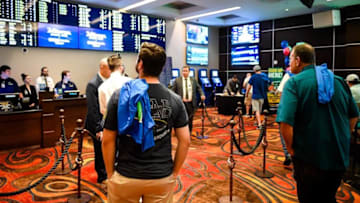Gamers look at the odds board before making bets at the opening of the William Hill Sports Book at the Tropicana Evansville Thursday. The sports-book features a 16-by-9 feet video wall, ten 65-inch viewing monitors, and 12 odds boards, September 12, 2019.09 12 19 Sportsbook 4