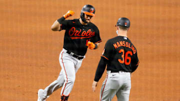 Apr 16, 2021; Arlington, Texas, USA; Baltimore Orioles third baseman Rio Ruiz (14) prepares to fist pump third base coach Tony Mansolino (36) after hitting a solo home run during the fourth inning against the Texas Rangers at Globe Life Field. Mandatory Credit: Raymond Carlin III-USA TODAY Sports