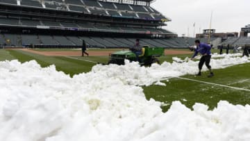 Apr 16, 2013; Denver, CO, USA; Colorado Rockies grounds crew remove snow from the field before the start of the game against the New York Metsat Coors Field. Mandatory Credit: Ron Chenoy-USA TODAY Sports