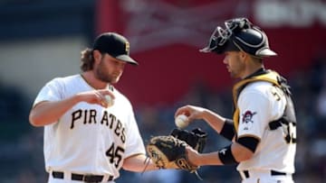 Sep 15, 2015; Pittsburgh, PA, USA; Pittsburgh Pirates starting pitcher Gerrit Cole (45) exchanges base balls with catcher Chris Stewart (19) against the Chicago Cubs during the seventh inning at PNC Park. The Pirates won 5-4. Mandatory Credit: Charles LeClaire-USA TODAY Sports